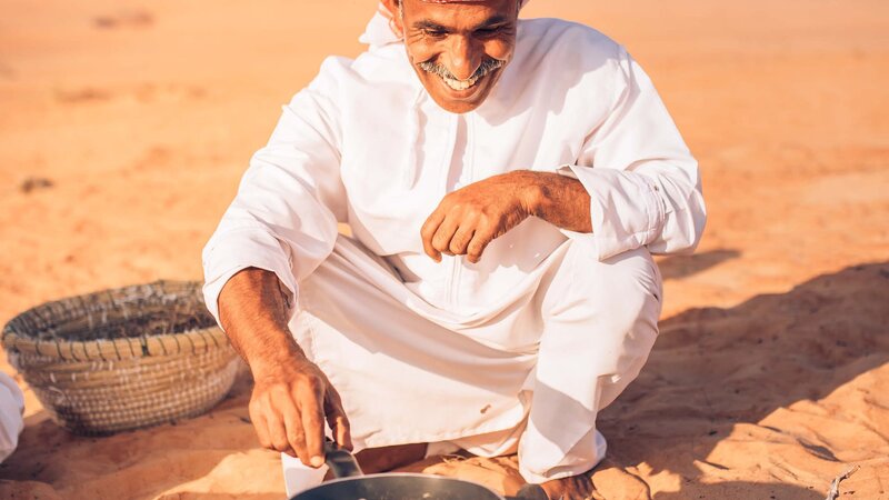 Oman-Wahiba Sands-Canvas Club-camp manager maakt ontbijt