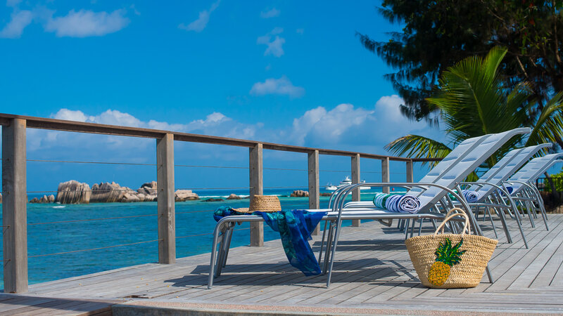 Seychellen-La-Digue-Le-Natautique-Waterfront-Hotel-sfeerbeeld-ligbedden-strandtas