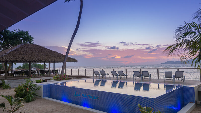 Seychellen-La-Digue-Le-Natautique-Waterfront-Hotel-zwembad-ligbedden-avond