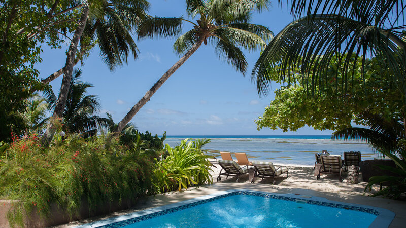 Seychellen-La-Digue-Le-Repaire-Boutique-Hotel-tuin-zwembad-zee-ligbedden
