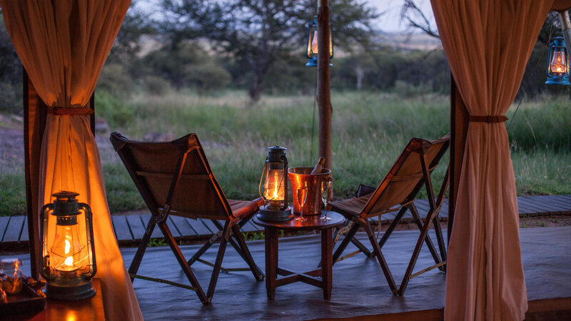 Tanzania-Serengeti NP-Elewana-Serengeti-Pioneer-Camp-sfeerbeeld-avond-lamp-stoeltjes