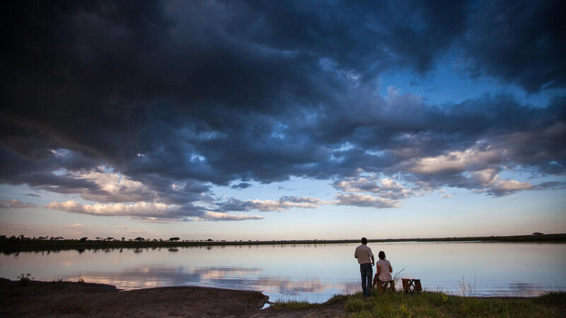Tanzania-Serengeti NP-Elewana-Serengeti-Pioneer-Camp-zonsondergang-koppel-bij-meer