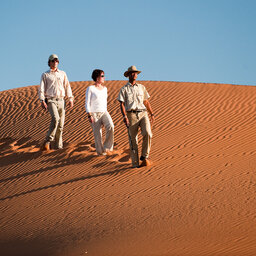 Namibië-algemeen-koppel wandelt in de duinen