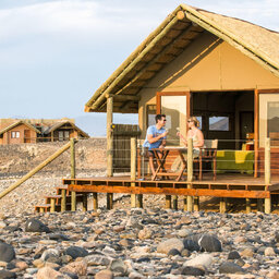 Namibie-Sossusvlei-Kulala-Desert-Lodge-hutje-mensen-op-terras