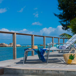 Seychellen-La-Digue-Le-Natautique-Waterfront-Hotel-sfeerbeeld-ligbedden-strandtas