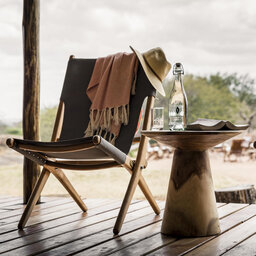 Tanzania-Serengeti NP-Sanctuary-Kusini-Camp-sfeerbeeld-stoel-met-tafel-op-deck